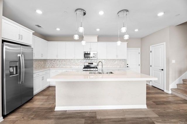 2167 Trevi Cir, Chula Vista, CA 91913 - kitchen featuring appliances with stainless steel finishes, light countertops, an island with sink, decorative backsplash, and recessed lighting