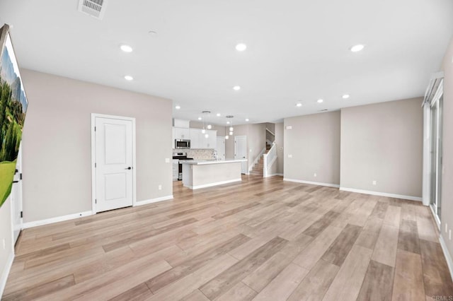 2167 Trevi Cir, Chula Vista, CA 91913 - unfurnished living room featuring recessed lighting, light wood finished floors, and stairs