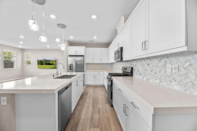 2167 Trevi Cir, Chula Vista, CA 91913 - kitchen with appliances with stainless steel finishes, light countertops, light wood finished floors, white cabinetry, and decorative backsplash