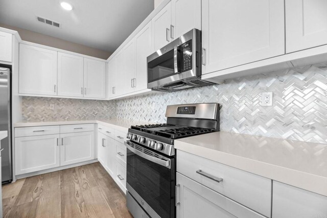 2167 Trevi Cir, Chula Vista, CA 91913 - kitchen with appliances with stainless steel finishes, light countertops, white cabinets, light wood-style floors, and recessed lighting