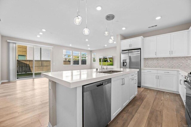 2167 Trevi Cir, Chula Vista, CA 91913 - kitchen featuring appliances with stainless steel finishes, light wood finished floors, an island with sink, light countertops, and recessed lighting