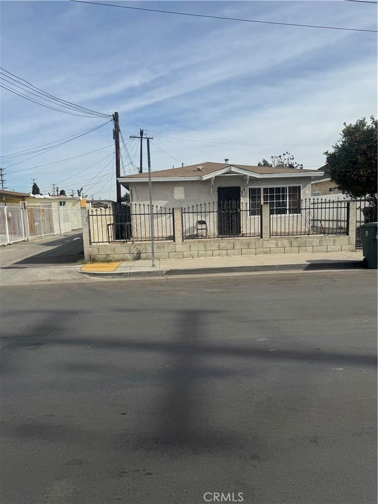 view of front facade featuring a fenced front yard and stucco siding