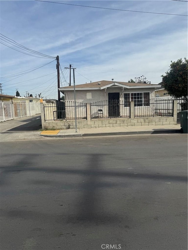 view of front facade featuring a fenced front yard and stucco siding