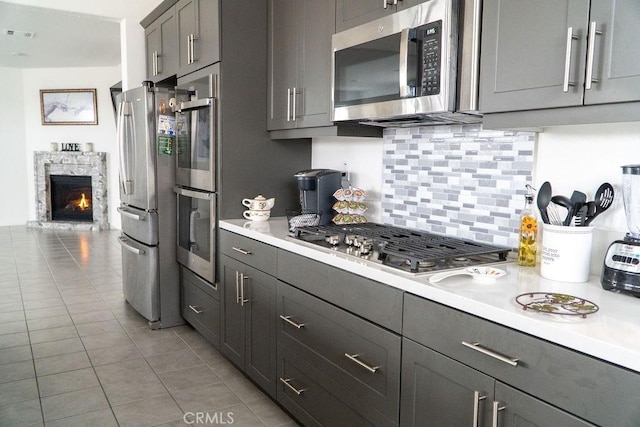 2373 Crater Ave, Rialto, CA 92377 - kitchen featuring stainless steel appliances, light countertops, gray cabinetry, backsplash, and light tile patterned floors