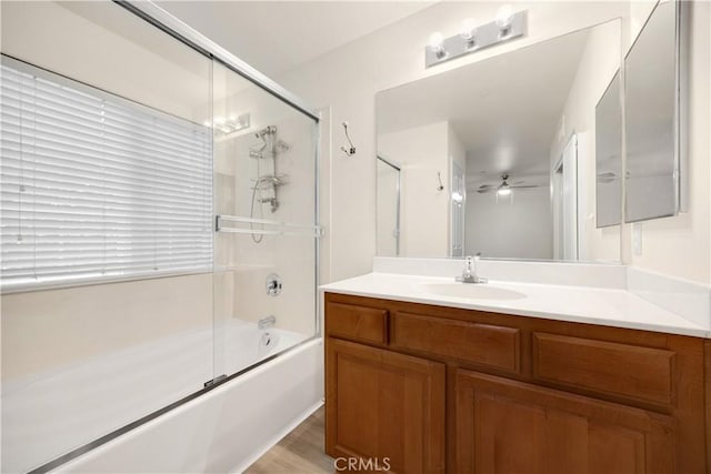 full bathroom with shower / bath combination with glass door, ceiling fan, and vanity
