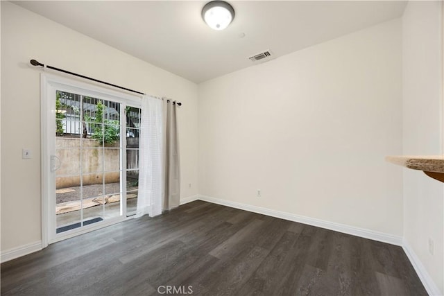 unfurnished room featuring dark wood-style floors and baseboards