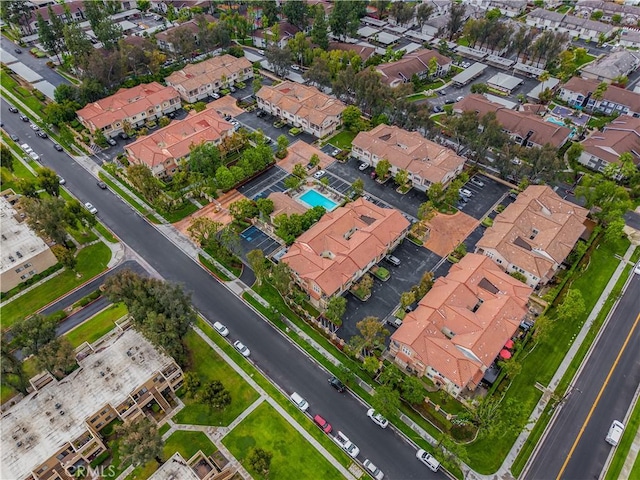 aerial overview of property's location featuring nearby suburban area and a pool area