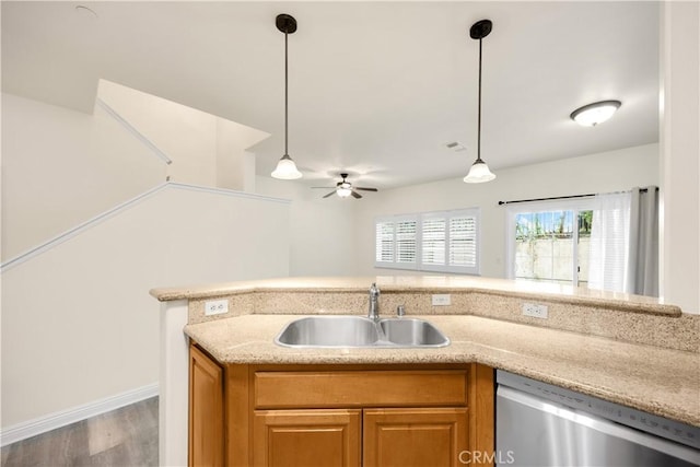 kitchen with dishwasher, a sink, a ceiling fan, wood finished floors, and pendant lighting