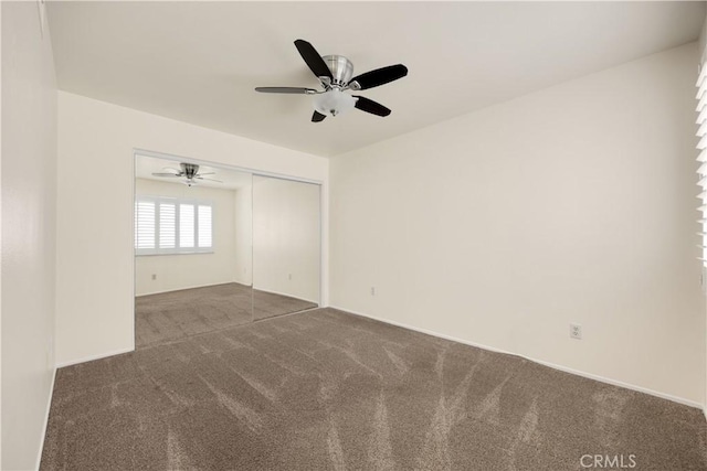 carpeted spare room with a ceiling fan