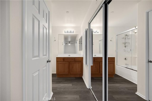 full bathroom with wood finished floors, vanity, and combined bath / shower with glass door