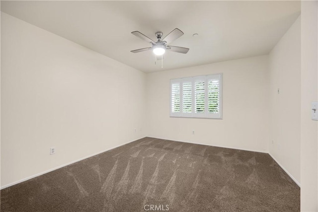 empty room with dark carpet and a ceiling fan