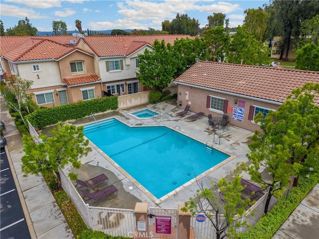 community pool featuring a hot tub and a patio