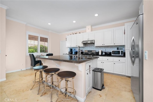 5581 Tremaine Way, Chino Hills, CA 91709 - kitchen with stainless steel appliances, under cabinet range hood, white cabinetry, baseboards, and crown molding
