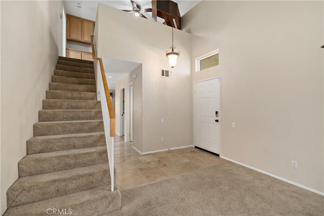 1044 Jude Ct, San Jacinto, CA 92583 - foyer with stairs, baseboards, a ceiling fan, light colored carpet, and a towering ceiling