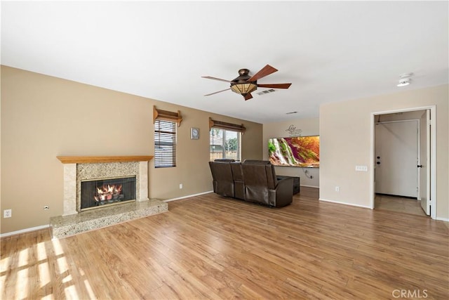 1044 Jude Ct, San Jacinto, CA 92583 - unfurnished living room featuring ceiling fan, wood finished floors, a premium fireplace, and baseboards