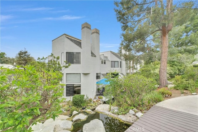 view of home's exterior with a chimney and stucco siding