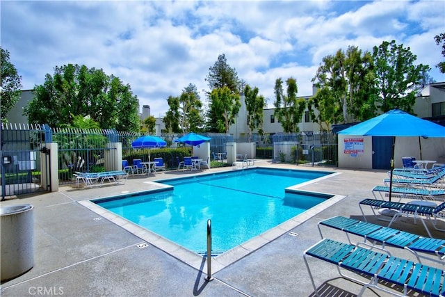 community pool featuring a patio and fence