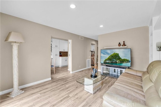 living room featuring light wood-style floors, baseboards, and recessed lighting