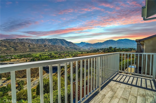 balcony at dusk featuring a mountain view