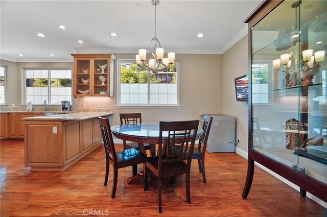 dining area featuring a chandelier, ornamental molding, light wood-style flooring, recessed lighting, and baseboards