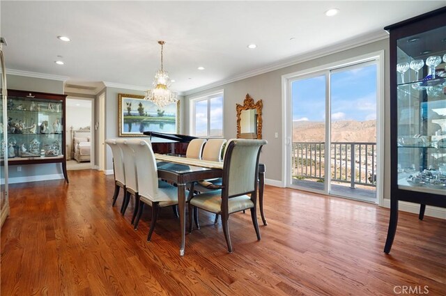 dining space featuring a chandelier, crown molding, plenty of natural light, wood finished floors, and recessed lighting