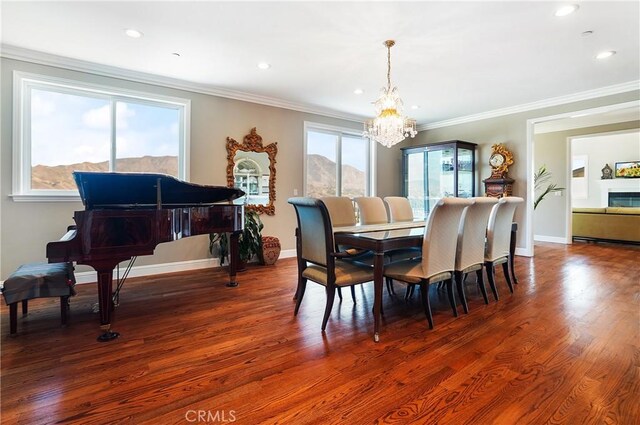dining area with a chandelier, ornamental molding, wood finished floors, recessed lighting, and baseboards