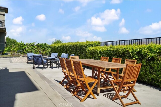 view of patio / terrace featuring outdoor dining space, agricultural area, and fence