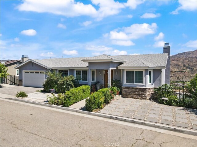 ranch-style home with stucco siding, fence, and a garage