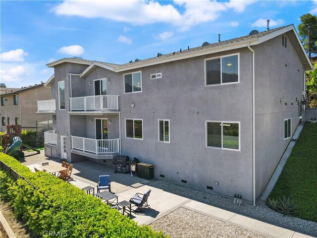 back of property featuring crawl space, stucco siding, a patio area, and a balcony