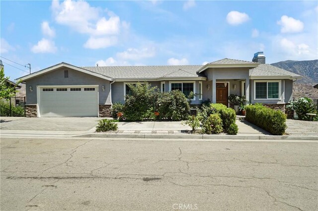view of front of home featuring a garage, stucco siding, concrete driveway, and stone siding