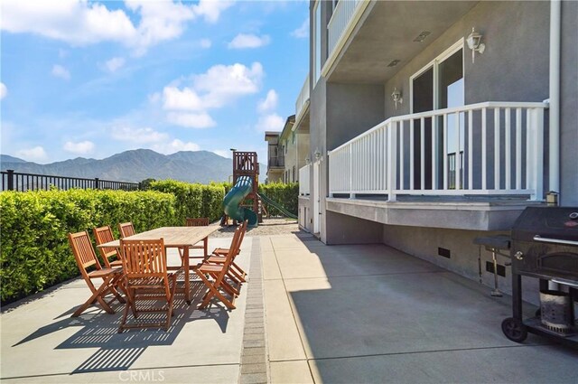 view of patio with a mountain view, outdoor dining area, and fence