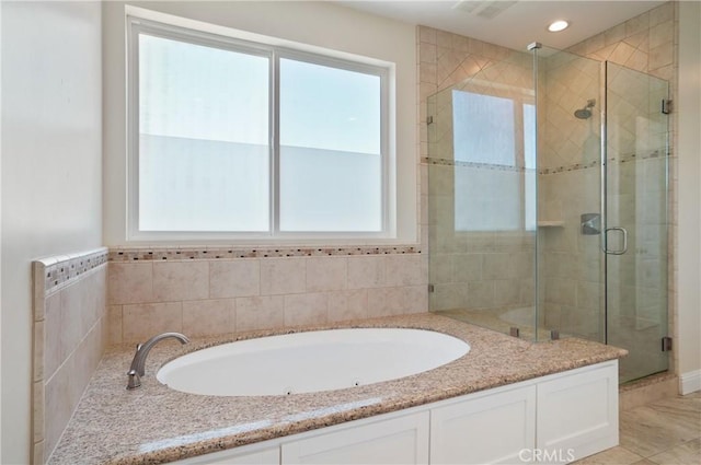 bathroom with plenty of natural light, a stall shower, a bath, and recessed lighting