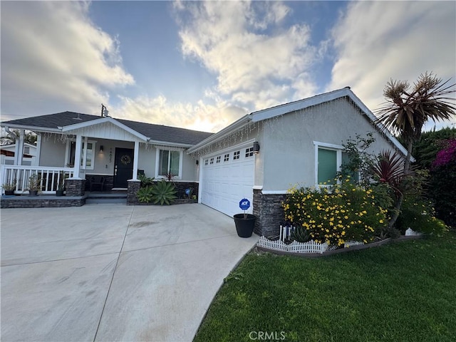 14825 Cranbrook Ave, Hawthorne, CA 90250 - view of front of house with stone siding, an attached garage, a porch, concrete driveway, and stucco siding