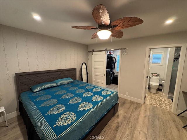 14825 Cranbrook Ave, Hawthorne, CA 90250 - bedroom featuring wood finished floors, a barn door, baseboards, a walk in closet, and recessed lighting