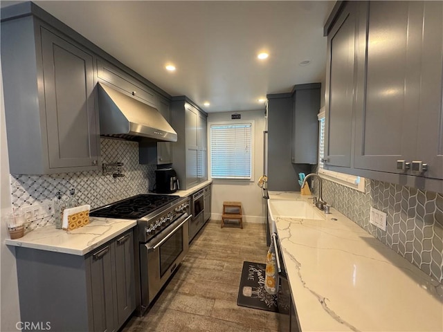 14825 Cranbrook Ave, Hawthorne, CA 90250 - kitchen featuring wall chimney range hood, high end stainless steel range oven, a sink, gray cabinets, and light stone counters