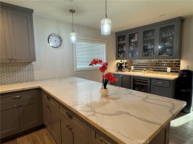 14825 Cranbrook Ave, Hawthorne, CA 90250 - kitchen with wine cooler, wood finished floors, tasteful backsplash, glass insert cabinets, and light stone counters