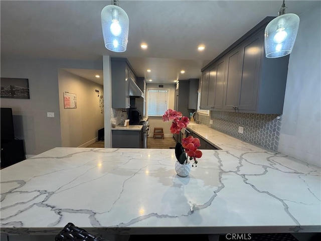 14825 Cranbrook Ave, Hawthorne, CA 90250 - kitchen featuring light stone counters, backsplash, gray cabinets, recessed lighting, and wall chimney range hood
