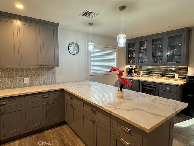14825 Cranbrook Ave, Hawthorne, CA 90250 - kitchen featuring beverage cooler, light wood finished floors, a peninsula, decorative backsplash, and glass insert cabinets