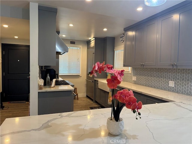 14825 Cranbrook Ave, Hawthorne, CA 90250 - kitchen with exhaust hood, light stone counters, backsplash, recessed lighting, and light wood-style flooring
