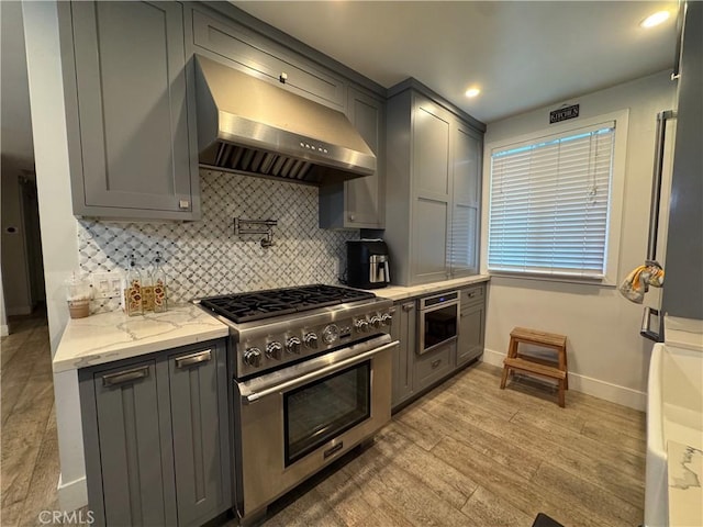 14825 Cranbrook Ave, Hawthorne, CA 90250 - kitchen featuring extractor fan, stainless steel stove, gray cabinetry, baseboards, and recessed lighting