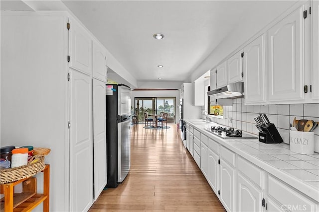 641 Sunnyhill Dr, Los Angeles, CA 90065 - kitchen featuring tile counters, appliances with stainless steel finishes, white cabinetry, under cabinet range hood, and light wood-type flooring