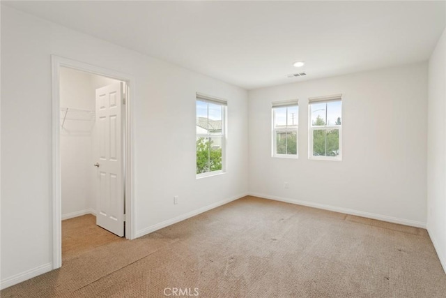 carpeted spare room featuring baseboards