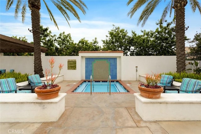 view of swimming pool featuring fence and a patio
