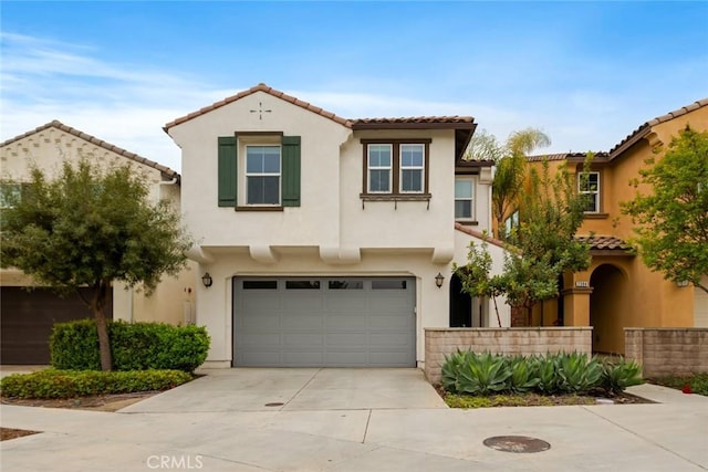 mediterranean / spanish-style home with a tile roof, driveway, a garage, and stucco siding