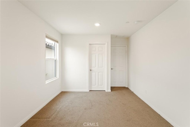 carpeted spare room featuring baseboards and recessed lighting