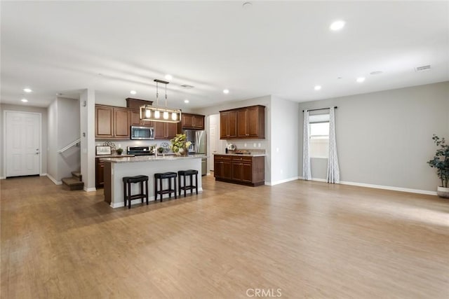 living room featuring recessed lighting, baseboards, light wood-type flooring, and stairs