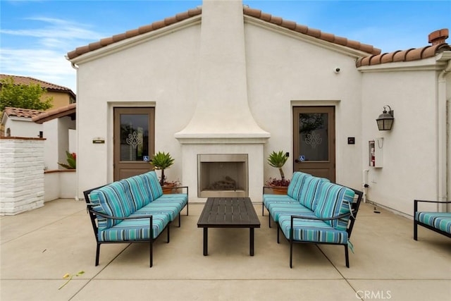 view of patio / terrace with an outdoor living space with a fireplace