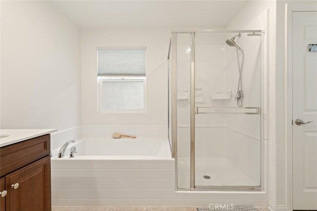 bathroom featuring a shower stall, vanity, and a bath