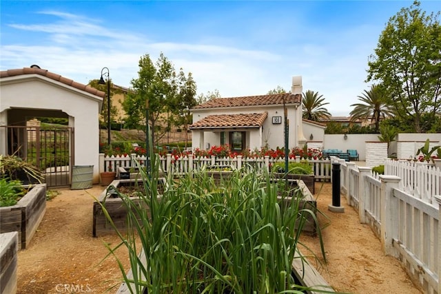 back of property with a tiled roof and stucco siding