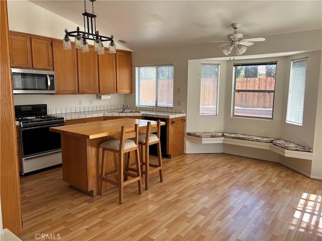 5314 Carlo Ct, Palmdale, CA 93552 - kitchen featuring stainless steel microwave, range with gas stovetop, light wood-style flooring, and wood counters